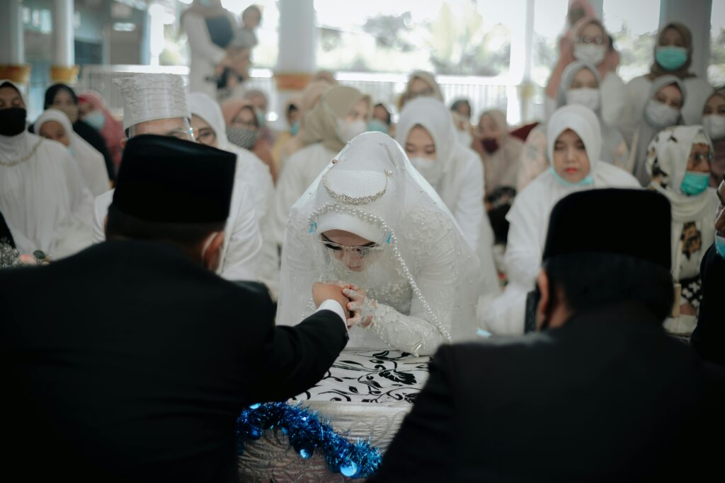 A bride in a traditional Islamic wedding ceremony, surrounded by family and friends, showcasing cultural attire and customs.
